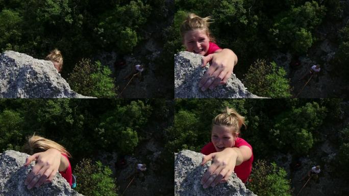 年轻女子爬上保护者上方陡峭的岩壁