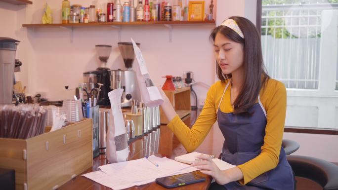 亚洲女咖啡师微笑着在咖啡店使用咖啡机柜台工作的女性小企业主餐饮咖啡馆概念