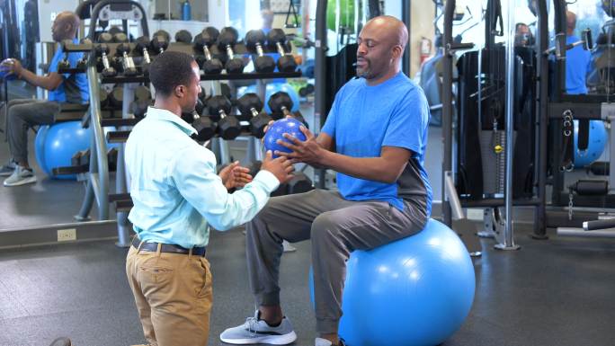 黑人男子用健身球做理疗