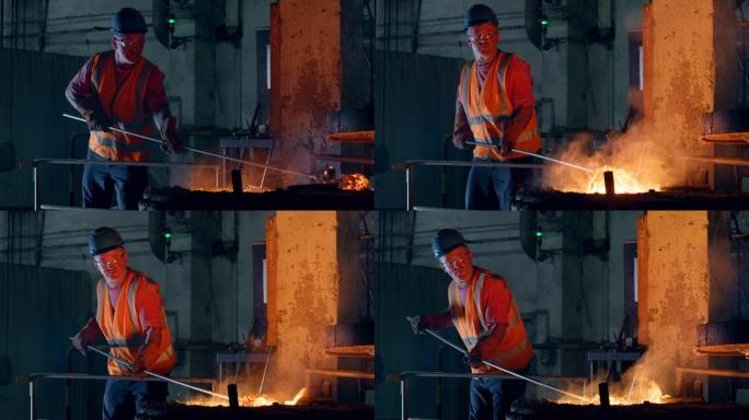 男工人在铸造厂清除熔融金属中的熔渣