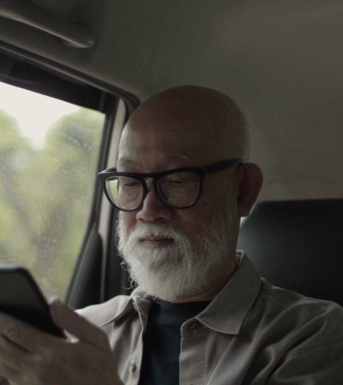 垂直视频格式：活跃的老人在车内使用手机