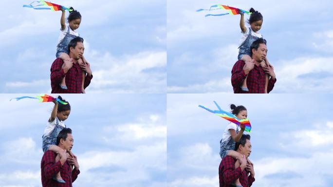 夏天，亚洲女孩和父亲在大自然的草地上欢快地放着风筝