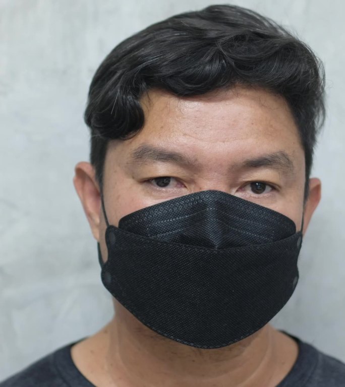 亚洲男人戴着面具，用面罩双重保护。