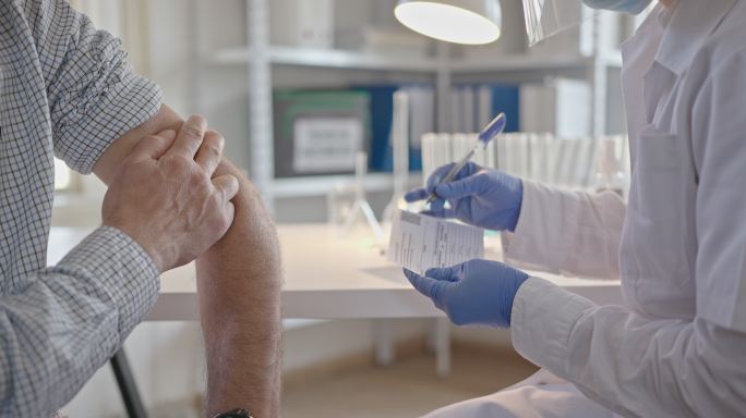 在疫苗接种中心向成年男子发放2019冠状病毒疾病疫苗接种证书。