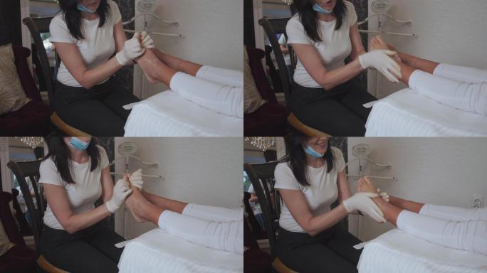 快乐的按摩治疗师在美容spa为年轻女性顾客按摩双脚
