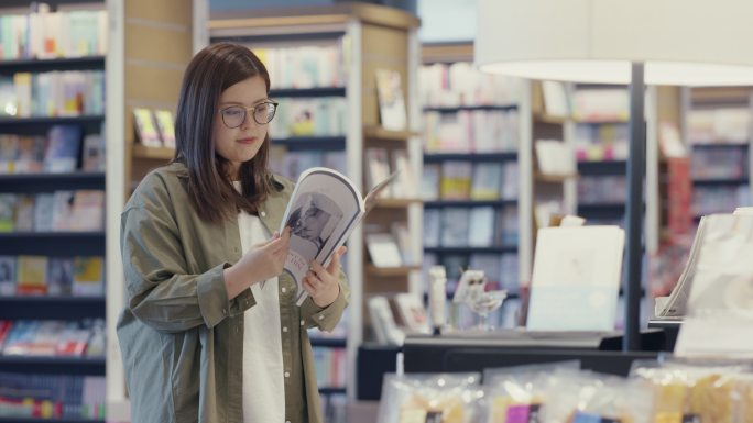 中景：一位年轻女子在商店里看杂志
