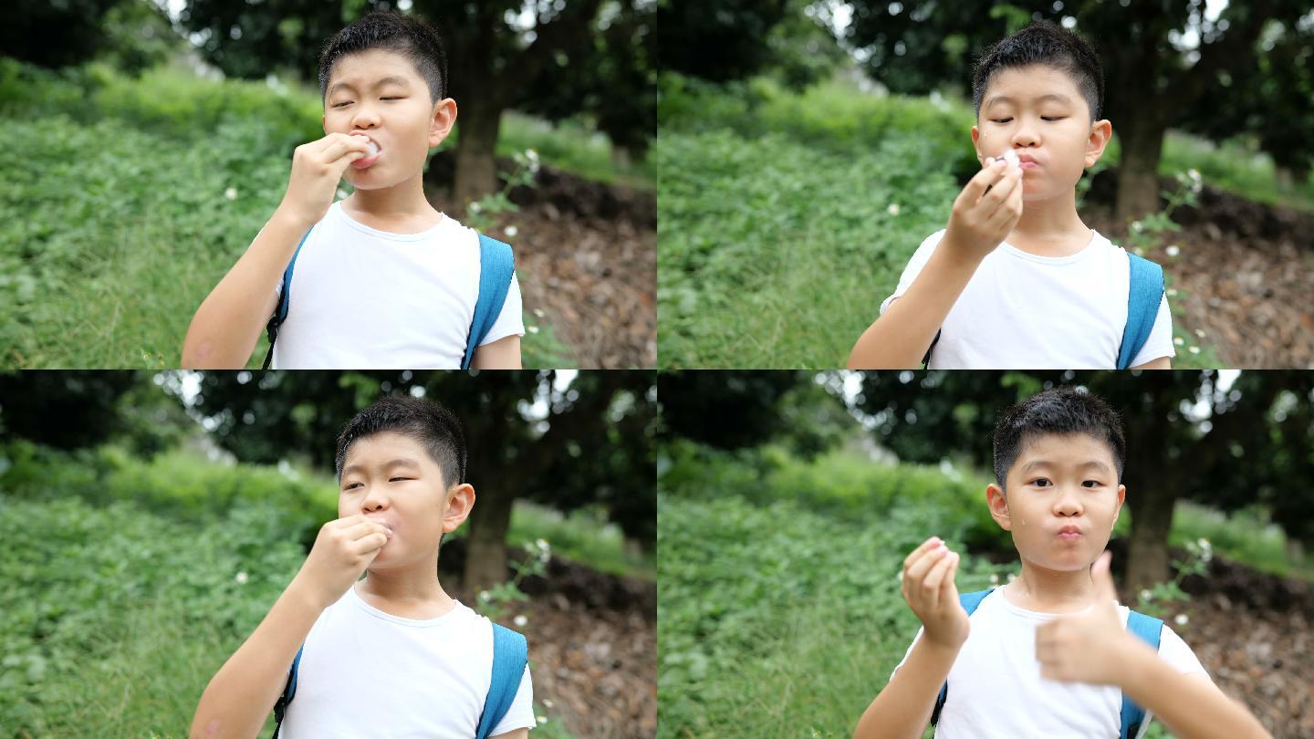 小男孩在户外吃荔枝竖起大拇指