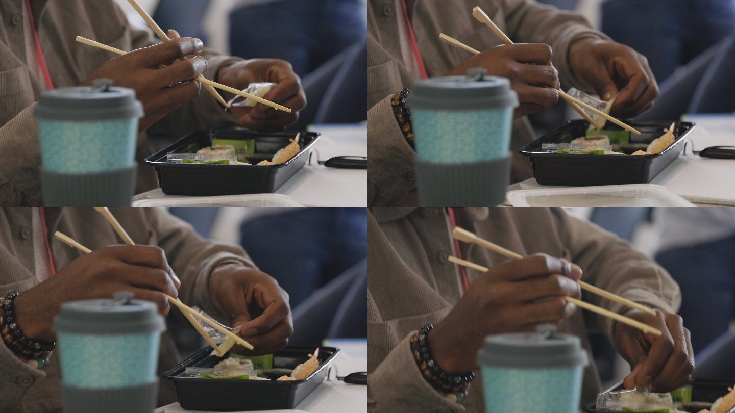 特写商人用筷子吃外卖寿司午餐