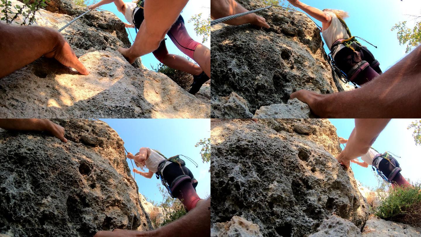 女登山者通过森林上方的费拉塔登上岩石
