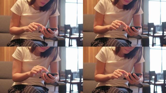 亚洲女性在咖啡馆使用智能手机进行社交媒体。