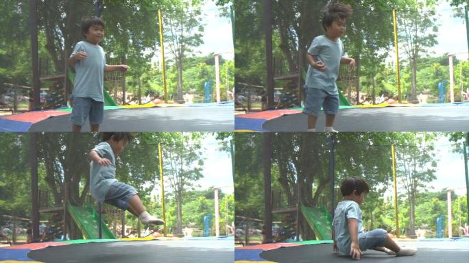 初学走路的男孩在操场蹦床上跳跃的慢动作