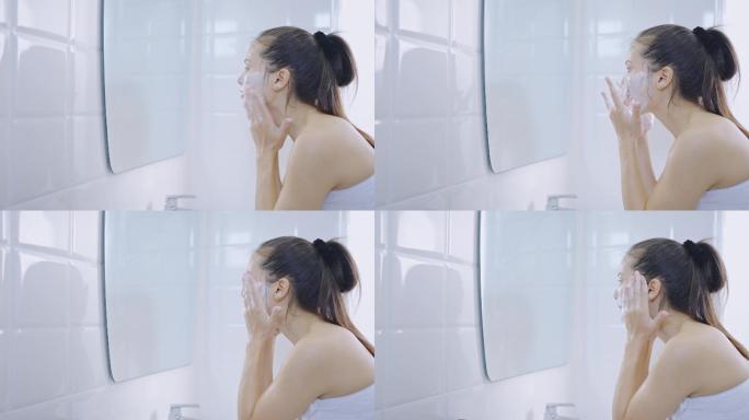在浴室用泡沫洗脸的女人