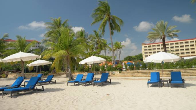 泰国华欣白色沙滩上，沙滩椅上挂着阳伞。