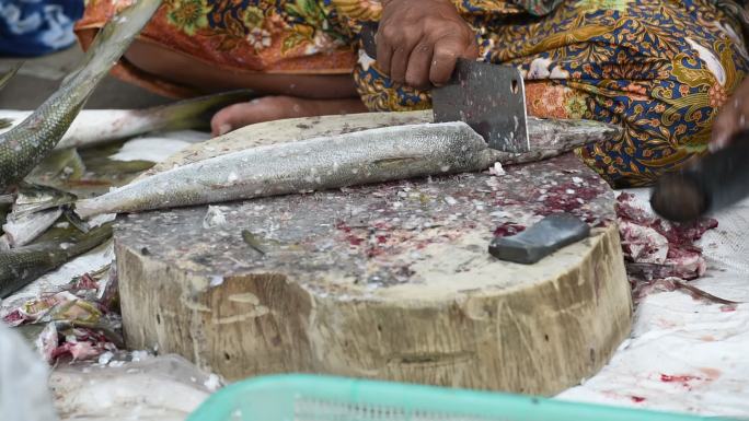 当地妇女在人行道上切鲜鱼、街头小吃