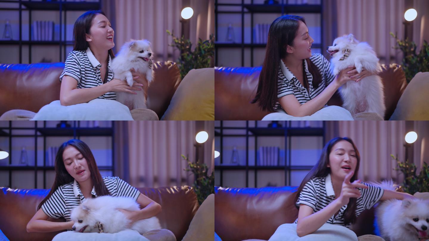 笑容可掬的亚洲女性坐在沙发上拥抱爱犬，与爱犬玩耍，狗主人和奇瓦瓦拉普多普在家度过周末快乐假期