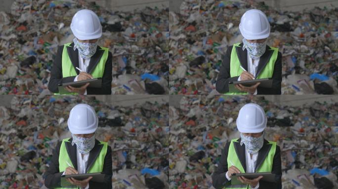 在2019冠状病毒疾病大流行的回收中心工作的工程师。在废物分离厂工作时，维护工程师戴着防护面罩。