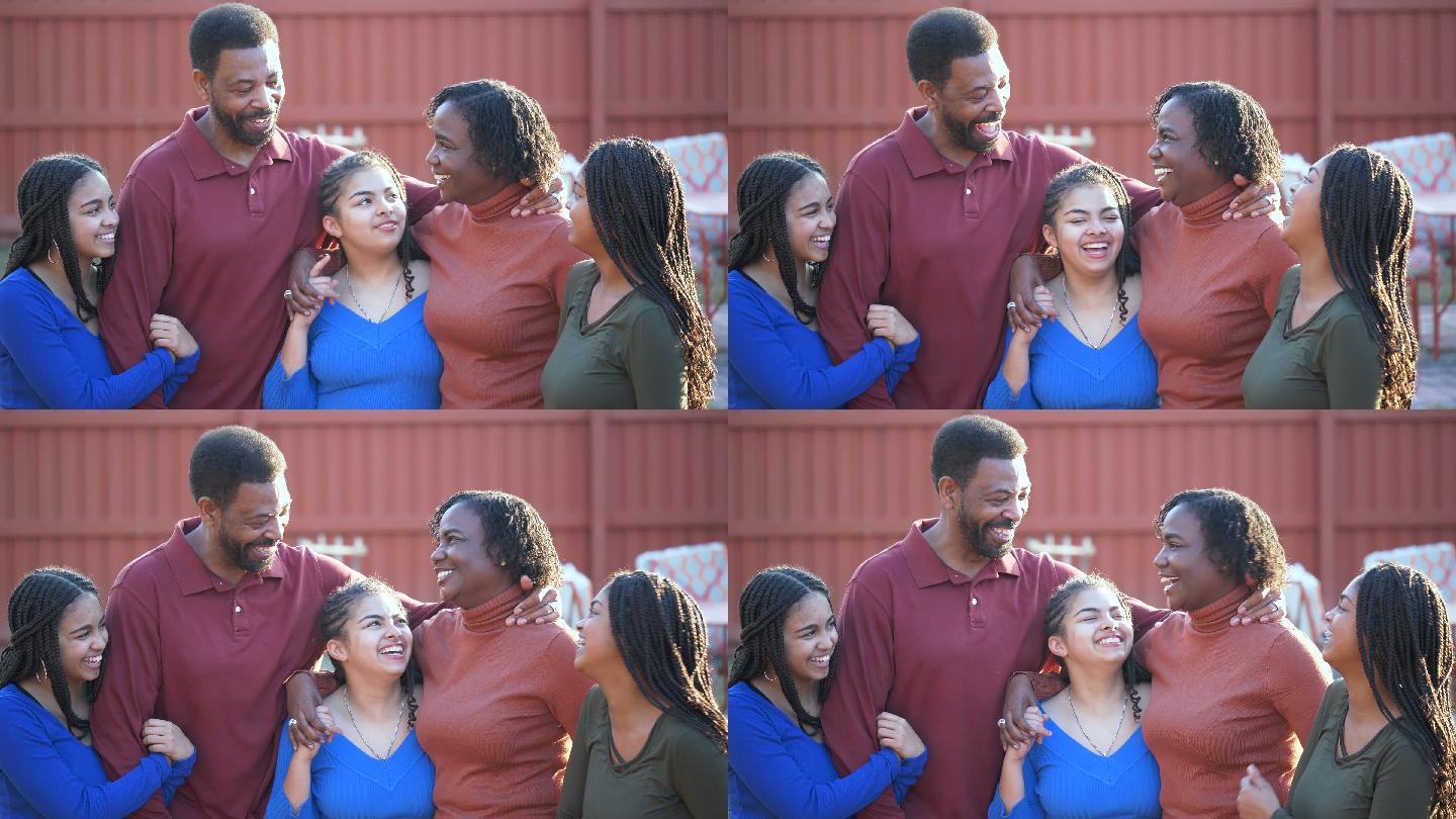 一个非裔美国人家庭和三个女孩在后院聊天