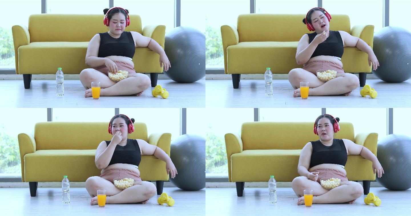 身材高大的女人在家听音乐，亚洲女孩喜欢在沙发上吃东西