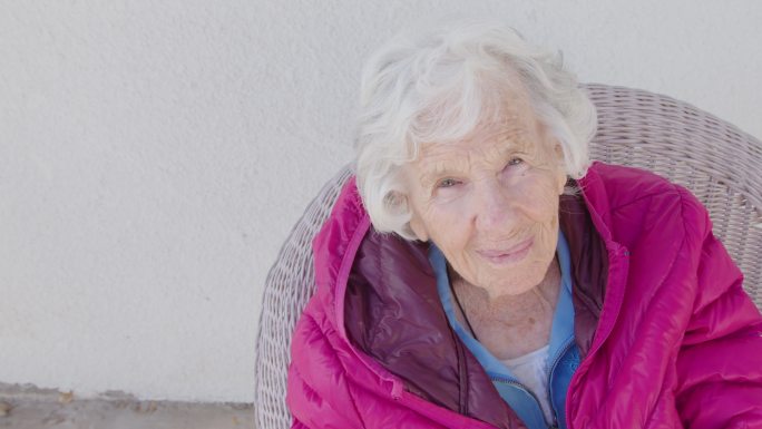 一位100岁高龄高加索人的可爱高角度肖像画，冬天坐在户外，有复印空间