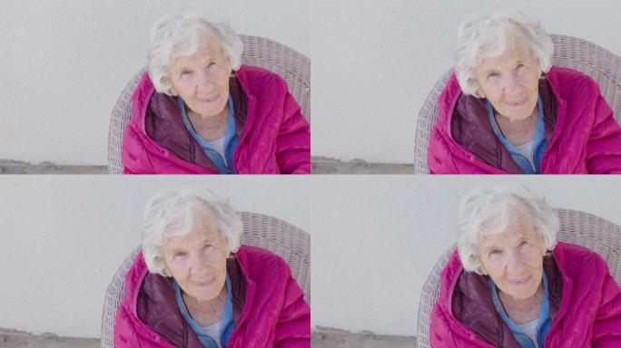 一位100岁高龄高加索人的可爱高角度肖像画，冬天坐在户外，有复印空间