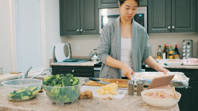 亚洲女性在厨房烹饪健康食品