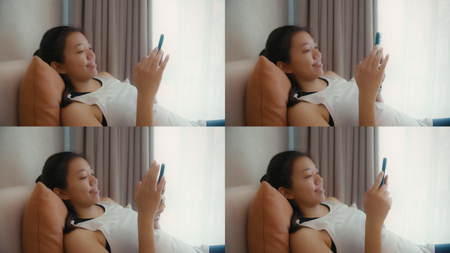 亚洲女性在家中卧室使用智能手机在线购物。