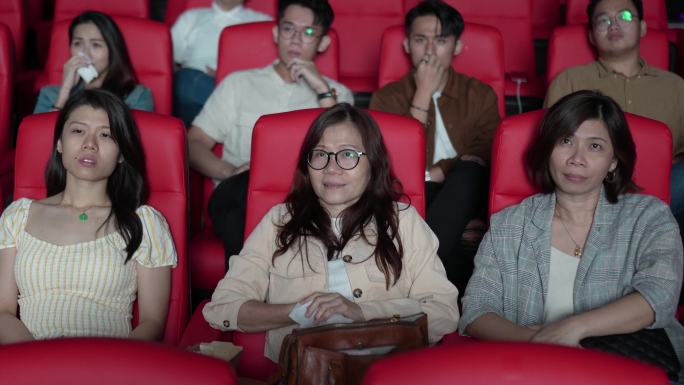 中国亚裔成熟女性与朋友在电影院看伤感电影