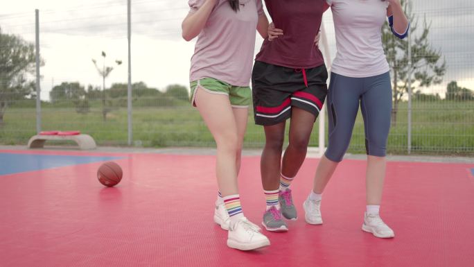 两名女队友在篮球场上帮助受伤的非洲女子