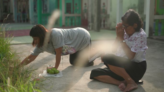 两名妇女在清明节为祖先祈祷