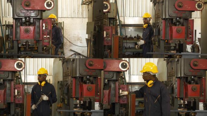 在工厂特写镜头中，在控制面板上工作的非裔美国人与一台工业机器一起工作。工业机械、男工程师检查工厂的自