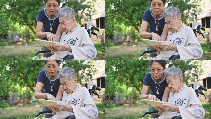 一位年老的残疾亚洲人坐在轮椅上，与家中的家人通过智能手机进行视频聊天