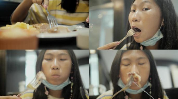 亚洲女孩在餐厅与家人一起吃烤鸡排，生活方式理念。