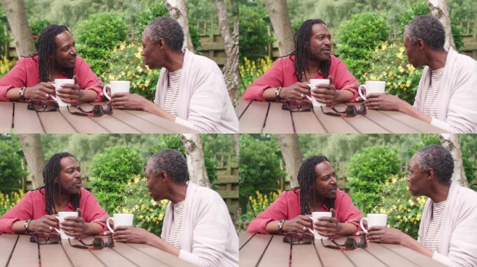 一对成年夫妇坐在室外花园里喝咖啡的4k视频片段