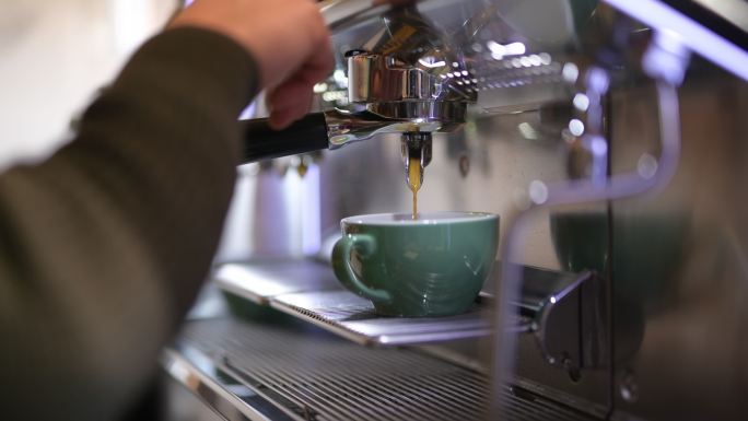 咖啡师在专业机器上煮咖啡的特写镜头。