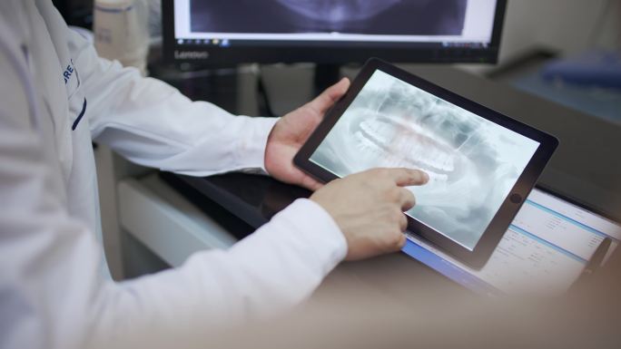 牙医在数字平板电脑中看x光片