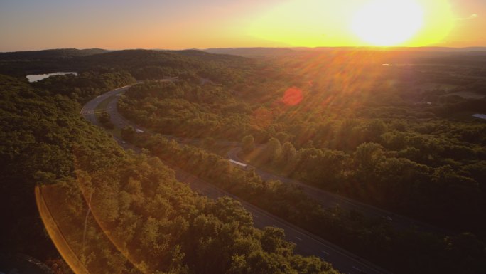 日落时分，在新泽西州I-80高速公路上，借助强烈的动态镜头光斑，在阳光下拍摄全景广角视图。具有下降摄
