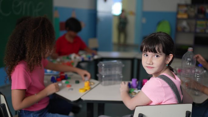 一个女孩在教室里分离回收材料的肖像