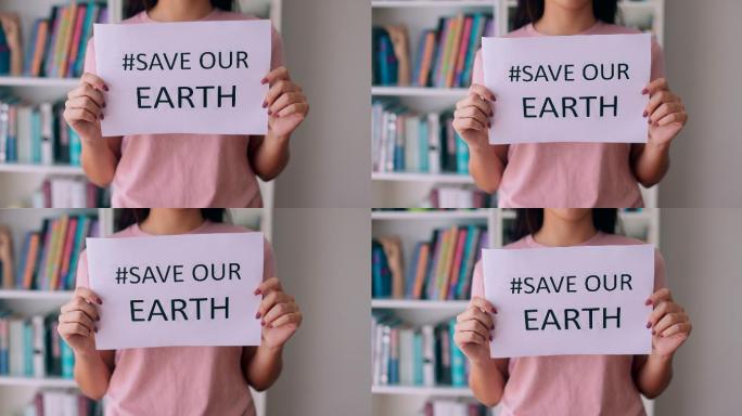 举着拯救地球标志的女人的特写镜头。