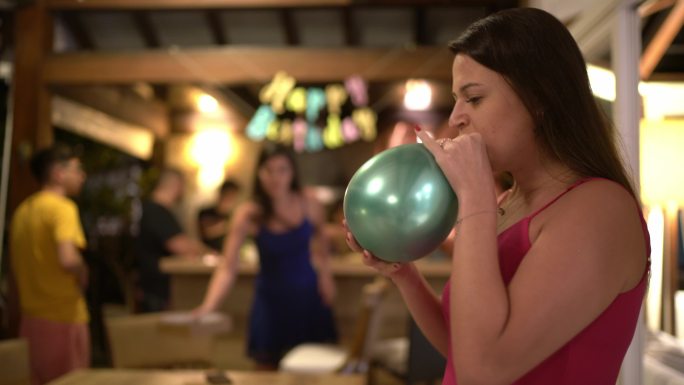 一位年轻女子在生日派对上吹气球的肖像