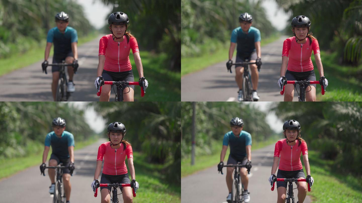 周末，一对精疲力竭的亚裔中国夫妇骑着公路自行车在炎热的阳光下一起在乡村骑行