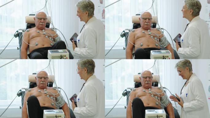 女治疗师在诊所与一位使用静态自行车的老年患者讨论