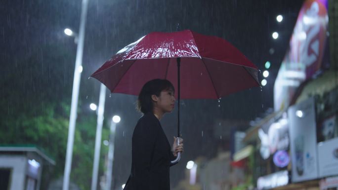 在雨中，一位亚洲妇女撑着雨伞。