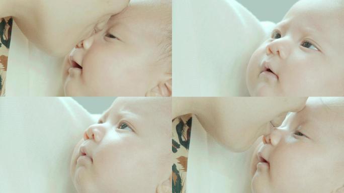 亚洲母亲在卧室里抱着并亲吻着混血可爱的新生女婴的鼻子