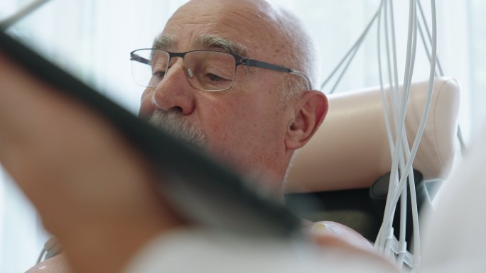 在心脏病诊所骑自行车进行心脏压力测试的老年男性患者