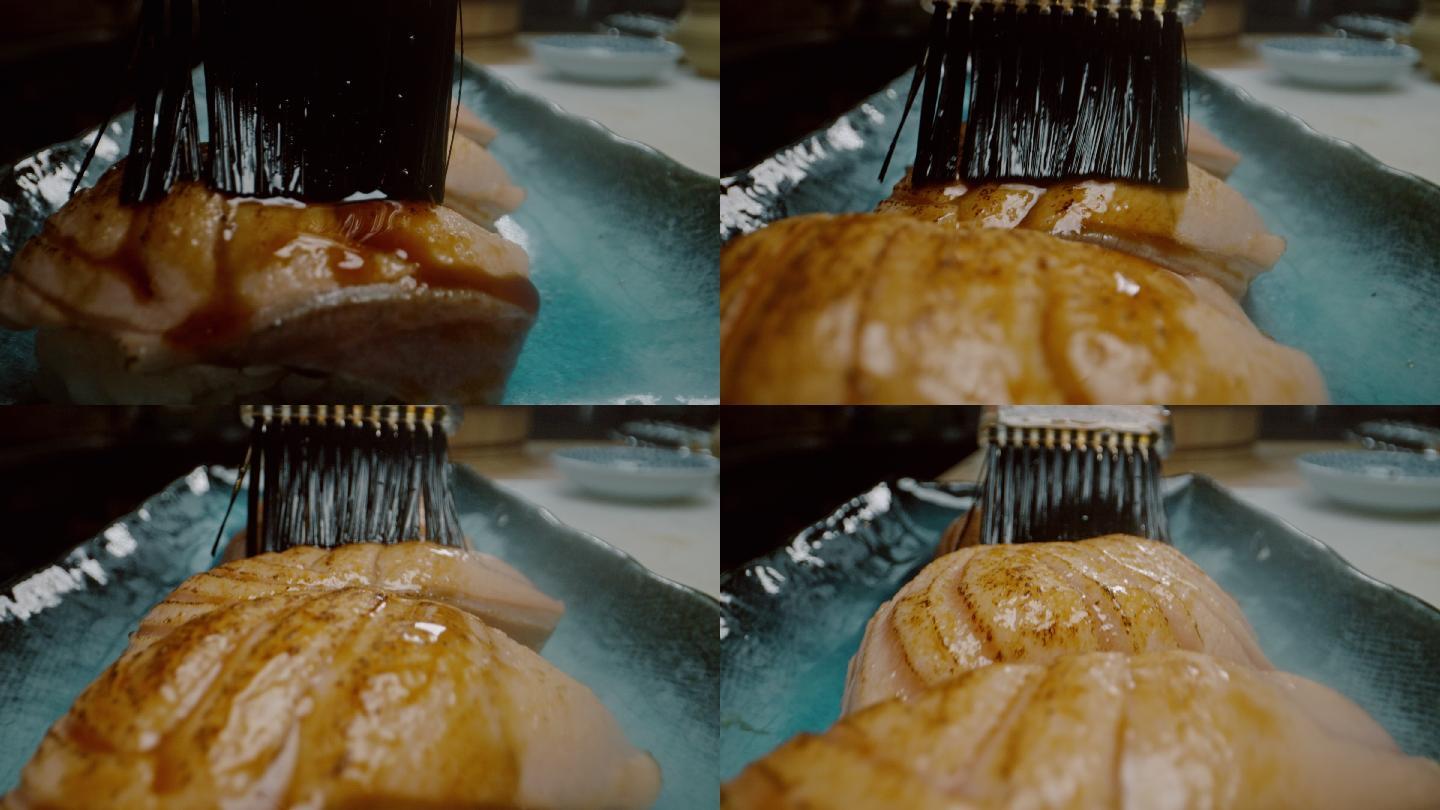 日本餐厅的日本厨师在三文鱼上涂酱汁