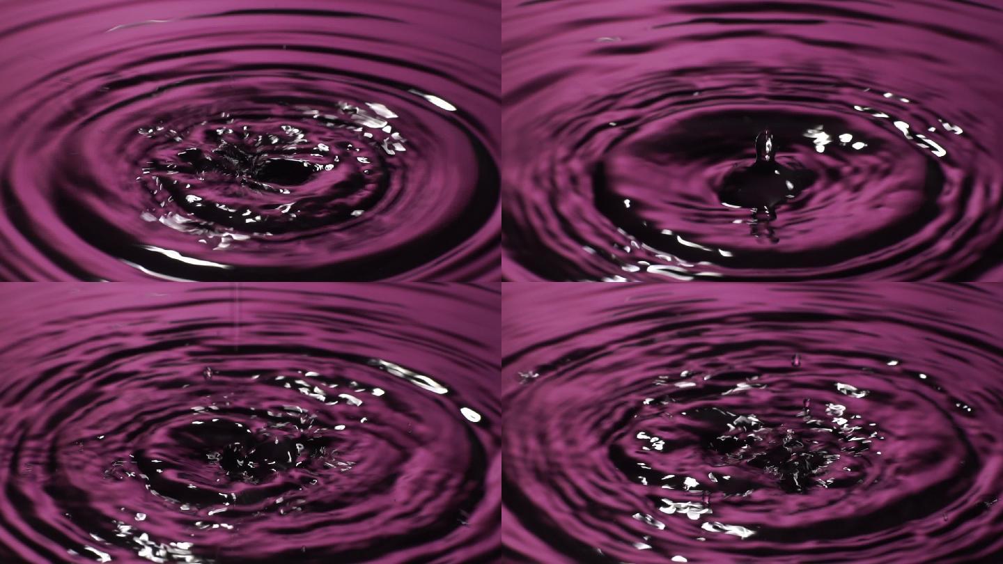 慢动作：许多水滴滴入粉红色的水中。