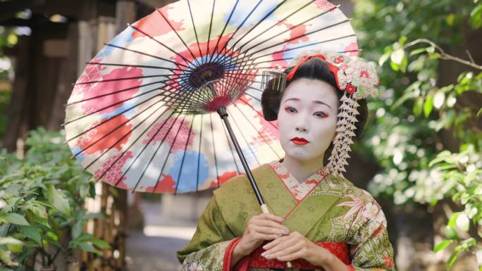 Maiko（艺妓在训练）在京都Gion的狭窄人行道上行走