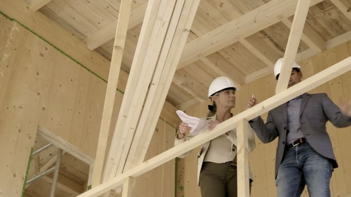 女建筑师和建筑工人在施工现场修改施工计划