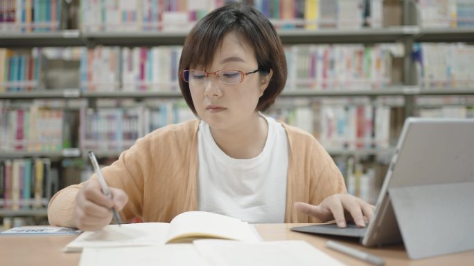 亚洲女性在图书馆使用笔记本电脑