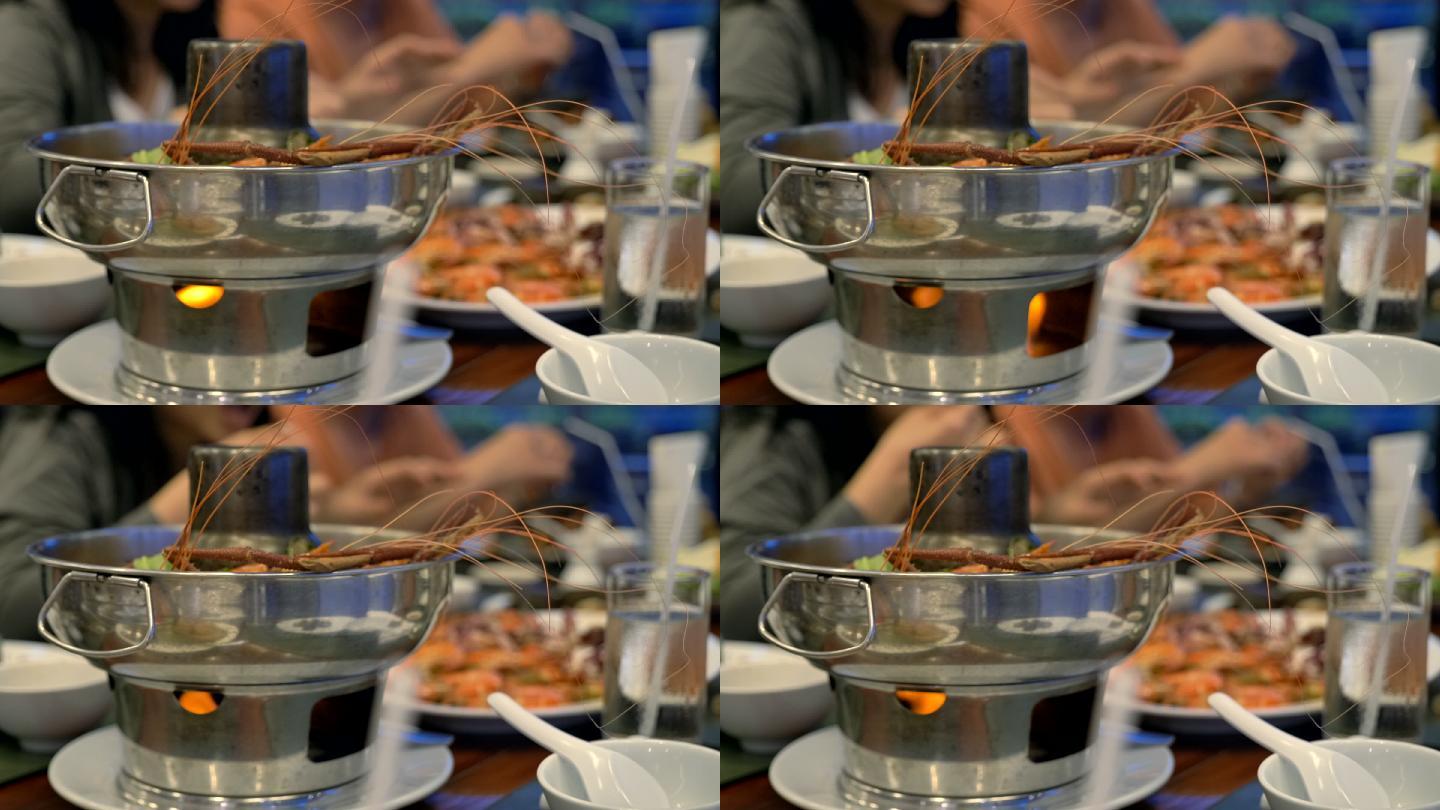 泰国辛辣食物慢镜头汤姆任功在餐厅的桌子上，人们在餐厅吃泰国食物